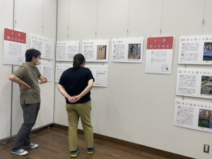 Two students looking at posters, as part of the exhibition titled Let’s Seek Family History at the gallery of the Kanazawa Ward Office in Yokohama City.